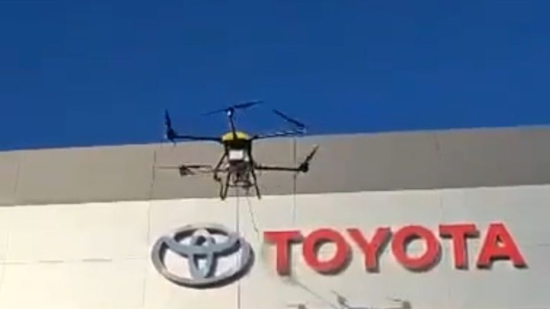 Drone limpiando fachada de concesionario Toyota